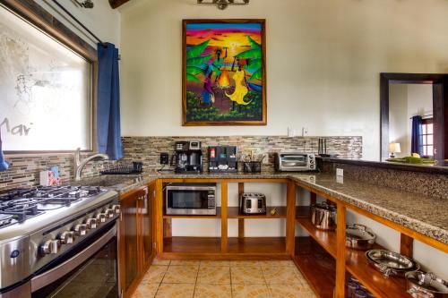 a kitchen with a stove and a counter top at Mariposa Belize Beach Resort in Placencia Village