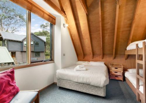 a small bedroom with a bed and a window at Coolong in Dinner Plain