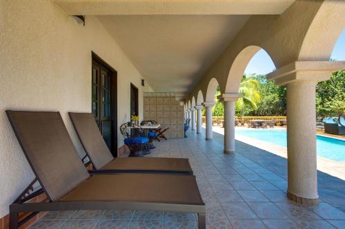 a porch of a house with a swimming pool at Mariposa Belize Beach Resort in Placencia Village