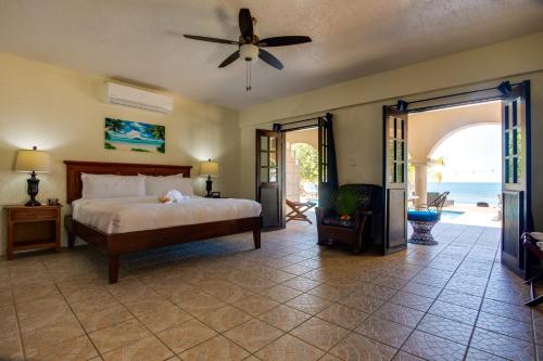 a bedroom with a bed and a ceiling fan at Mariposa Belize Beach Resort in Placencia Village