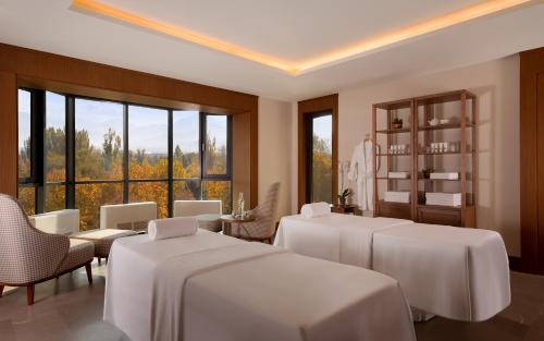 a room with four beds and a room with windows at Swissôtel Wellness Resort Alatau Almaty in Almaty