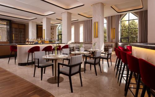 a restaurant with tables and chairs and a bar at Swissôtel Wellness Resort Alatau Almaty in Almaty