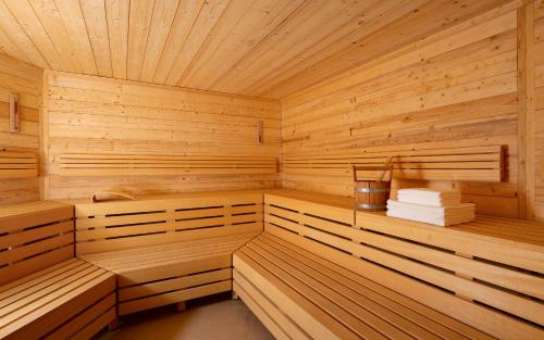 a sauna with wooden paneling and a bucket of towels at Swissôtel Wellness Resort Alatau Almaty in Almaty