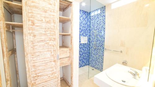 uma casa de banho com um chuveiro e um lavatório. em Ocean Star Apartment Sanur em Sanur