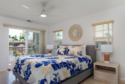1 dormitorio con 1 cama con edredón azul y blanco en Waikoloa Colony Villas #2105, en Waikoloa