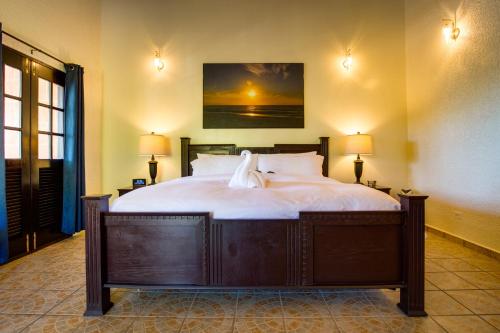 a bedroom with a large bed with two lamps at Mariposa Belize Beach Resort in Placencia Village