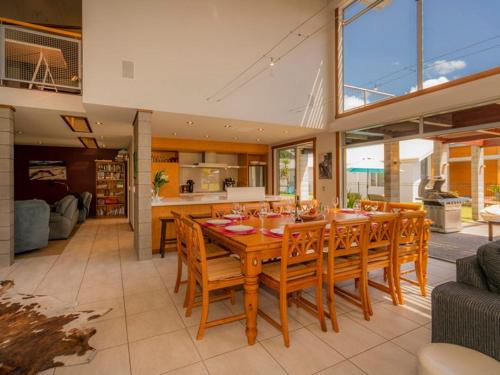 a dining room with a wooden table and chairs at Hosts on the Coast Whitianga Bliss in Whitianga