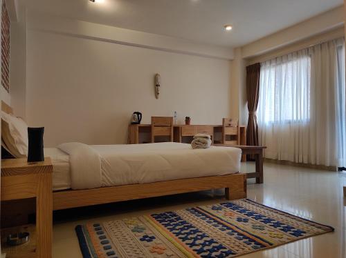 1 dormitorio con 1 cama grande y 1 alfombra en Sayami Home, en Pātan