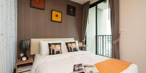 Un dormitorio con una cama con zapatillas. en Zcape2 Condominium en Thalang