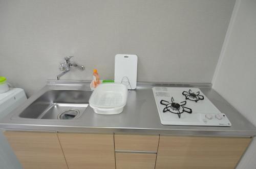 a kitchen counter top with a sink and a stove at Amont Nakamura - Vacation STAY 83274 in Miyazaki