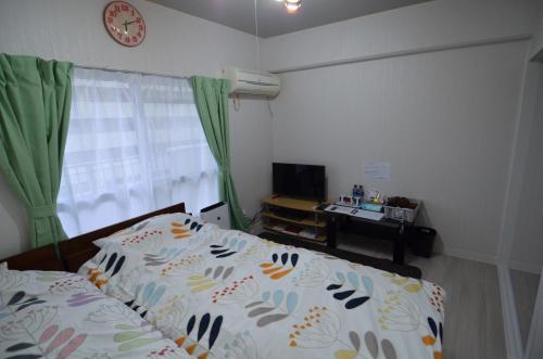 a bedroom with a bed and a clock on the wall at Amont Nakamura - Vacation STAY 83274 in Miyazaki