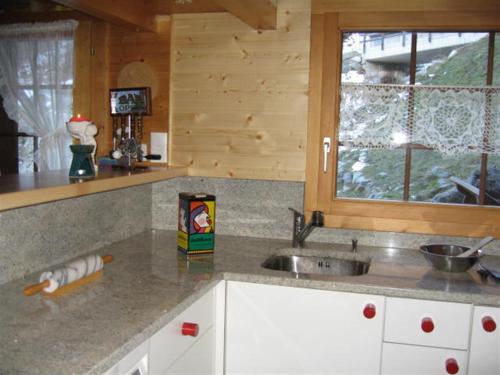 eine Küchentheke mit einem Waschbecken und einem Fenster in der Unterkunft Chalet Verano in Grimentz