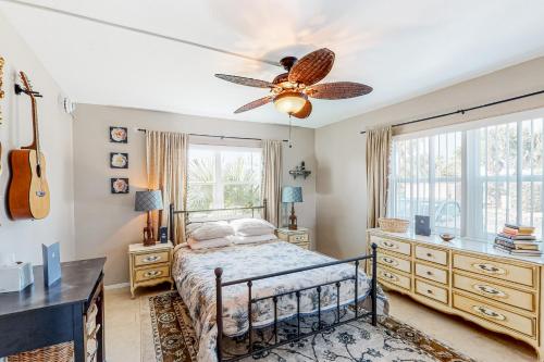 una camera da letto con un letto e un ventilatore a soffitto di Coral Paradise a Satellite Beach