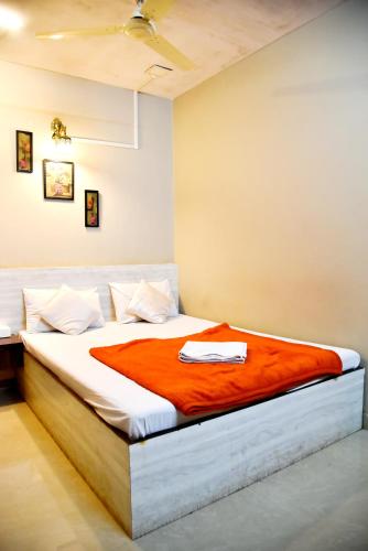 a bedroom with a bed with an orange blanket at DV INNS FARMVILLA - Besides Strawberry Farms in Mahabaleshwar
