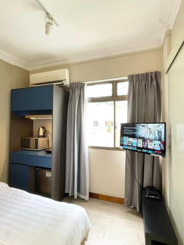 a bedroom with a bed and a tv on a wall at Greatwood Residence at Devonshire in Singapore