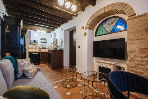 sala de estar con sofá y chimenea con TV en Corduba Suite, en Córdoba