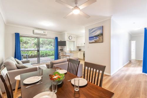a dining room and living room with a table and chairs at 4 'Adriana', 83 Ronald Avenue - open plan living with backyard in Shoal Bay