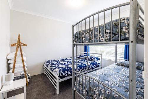 a bedroom with two bunk beds and a cross at Adriana 4 open plan living with backyard in Shoal Bay