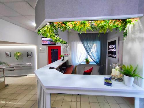 a waiting room with a counter with plants on the wall at Great Polonia Beach & Molo in Puck