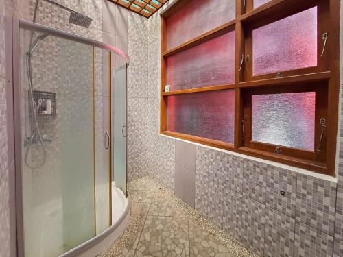 een badkamer met een douche, een toilet en een raam bij Pakde air cafe and homestay Grabag Magelang Mitra RedDoorz in Bedono