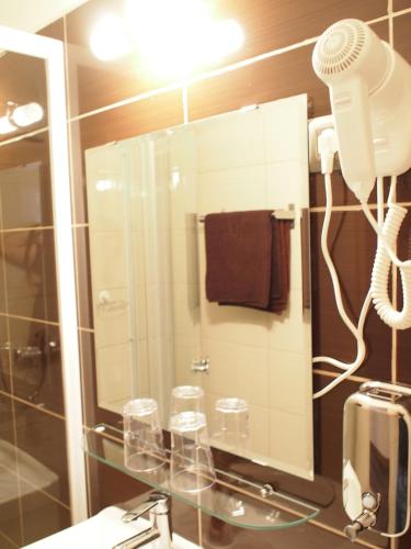 a bathroom with a mirror and a blow dryer at Budapest Suites in Budapest