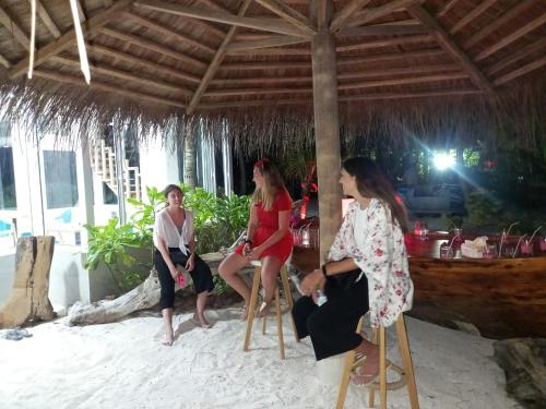 a group of women sitting in chairs in the sand at Island Life Maldives Retreat & Spa in Magoodhoo