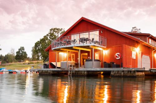 a red house on a dock on the water at Skärgårdsbyn S:t Anna in Mon