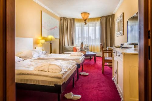 Una habitación de hotel con dos camas y un escritorio. en Villa St. Tropez, en Praga