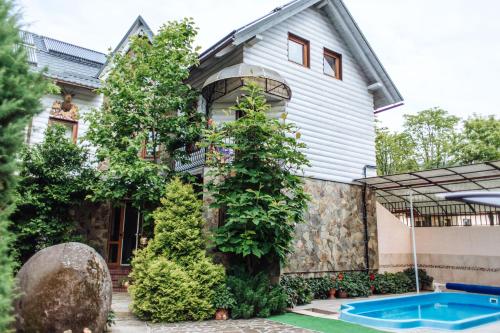a house with a swimming pool in front of it at Hotel Velyka Vedmedytsya in Yaremche