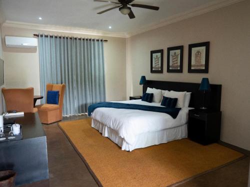 a bedroom with a bed and a ceiling fan at Umdlalo Lodge in Port Shepstone