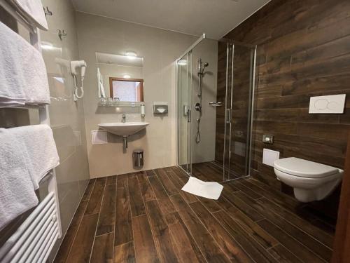 a bathroom with a toilet and a sink and a shower at Hotel U Kvapilů in Mnichovo Hradiště