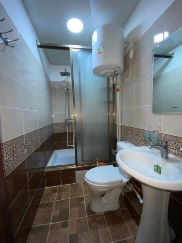 a bathroom with a toilet and a sink and a shower at Bahri Tojik Resort & Spa in Kairakum