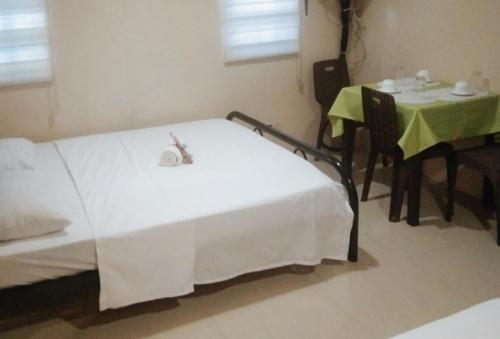 a bedroom with a bed and a table and a table and chair at Skyleigh Apartelle by RedDoorz in Iloilo City