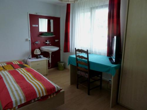 a bedroom with a table and a bed and a window at Backpackers Gasthaus Post in Willisau