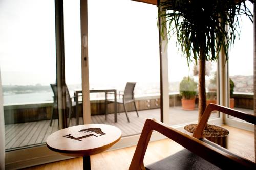 a table and chairs in a room with a balcony at Witt Istanbul Suites in Istanbul