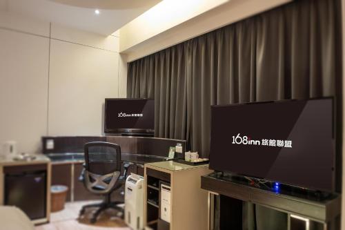a hotel room with a television and a desk with a chair at 168 Motel-Hsinchu in Hsinchu City