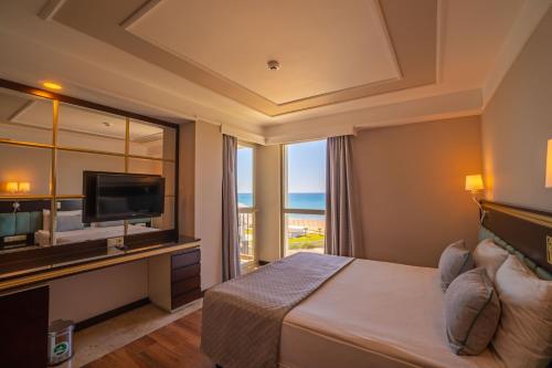 a hotel room with a bed and a television at Royal Atlantis Spa & Resort in Side