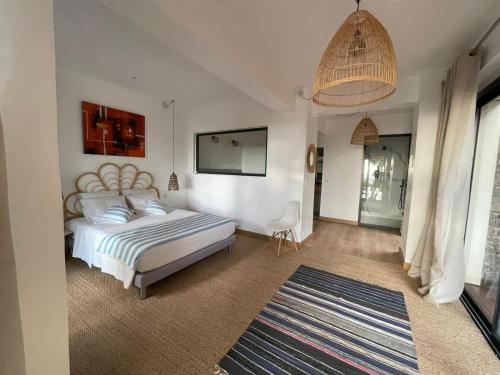 a bedroom with a bed and a chandelier at Villa Prana in La Saline les Bains