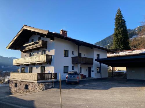 a building with a car parked in front of it at Frühstückspension & Appartements Eugenie in Kitzbühel
