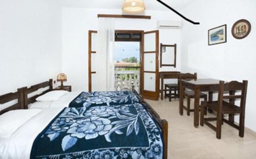 a bedroom with a bed and a desk and a table at Tzilios Studios in Acharavi