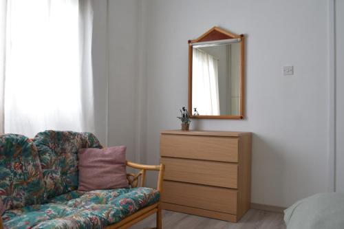 a bedroom with a dresser and a chair and a mirror at MAMA'S FLAT - ΤΟ ΔΙΑΜΕΡΙΣΜΑ ΤΗΣ ΜΑΜΑΣ in Strovolos