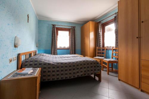 - une chambre avec un lit, une table et des fenêtres dans l'établissement Appartamento Campacc, à Livigno