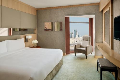 a hotel room with a bed and a chair and a window at InterContinental Al Khobar by IHG in Al Khobar