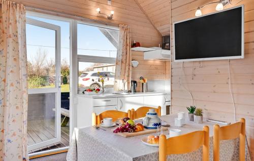 a kitchen and dining room with a table and a tv at Toftum Bjerge Camping & Cottages in Humlum
