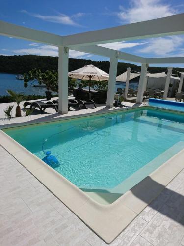 ein großer Pool in einem Resort mit Sonnenschirm in der Unterkunft Apartment Marta in Rab