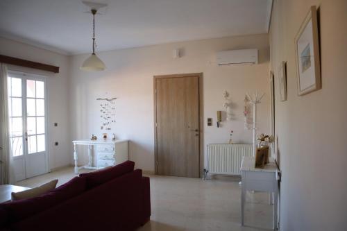 een woonkamer met een bank en een houten deur bij Helena Apartment Argostoli in Argostoli