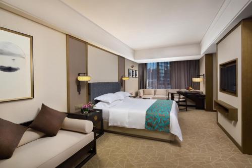 a hotel room with a bed and a living room at Yue Yang Hotel in Yueyang