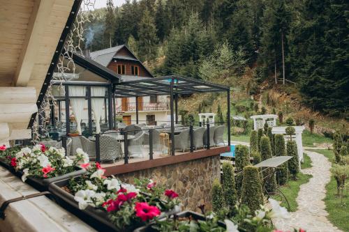 a balcony with chairs and flowers on a house at Hotel Vedmezhyi Dvir in Bukovel