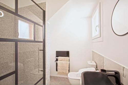 une salle de bain avec toilettes, lavabo et miroir dans l'établissement Casa Marana Plage, à Bastia
