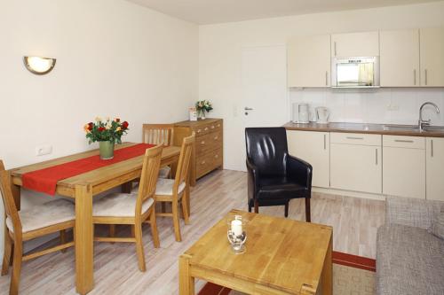 a living room with a table and a kitchen at Ferienwohnung Mare Nostrum 11 in Westerland